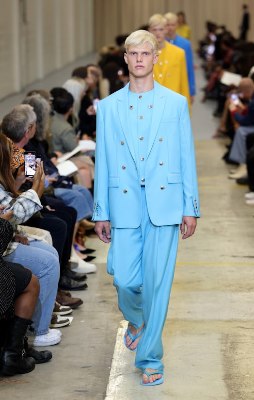 A male model walking the runway at the Burberry show during London Fashion Week in a light blue blaz...