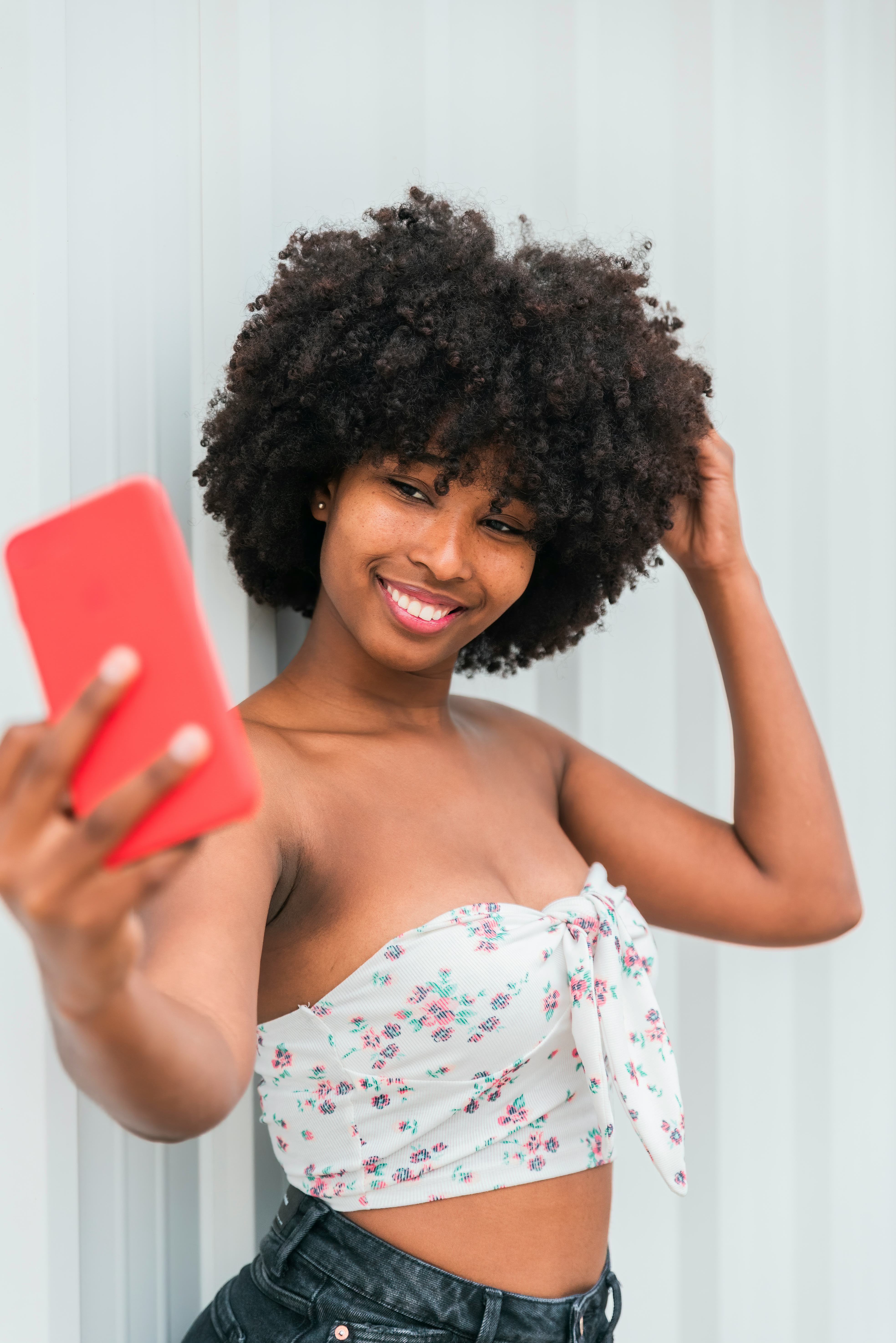 Young woman taking a selfie with her hand in her hair during the luckiest day in October 2022 for ev...