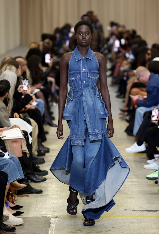 A female model walking the runway at the Burberry show during London Fashion Week in a denim overall