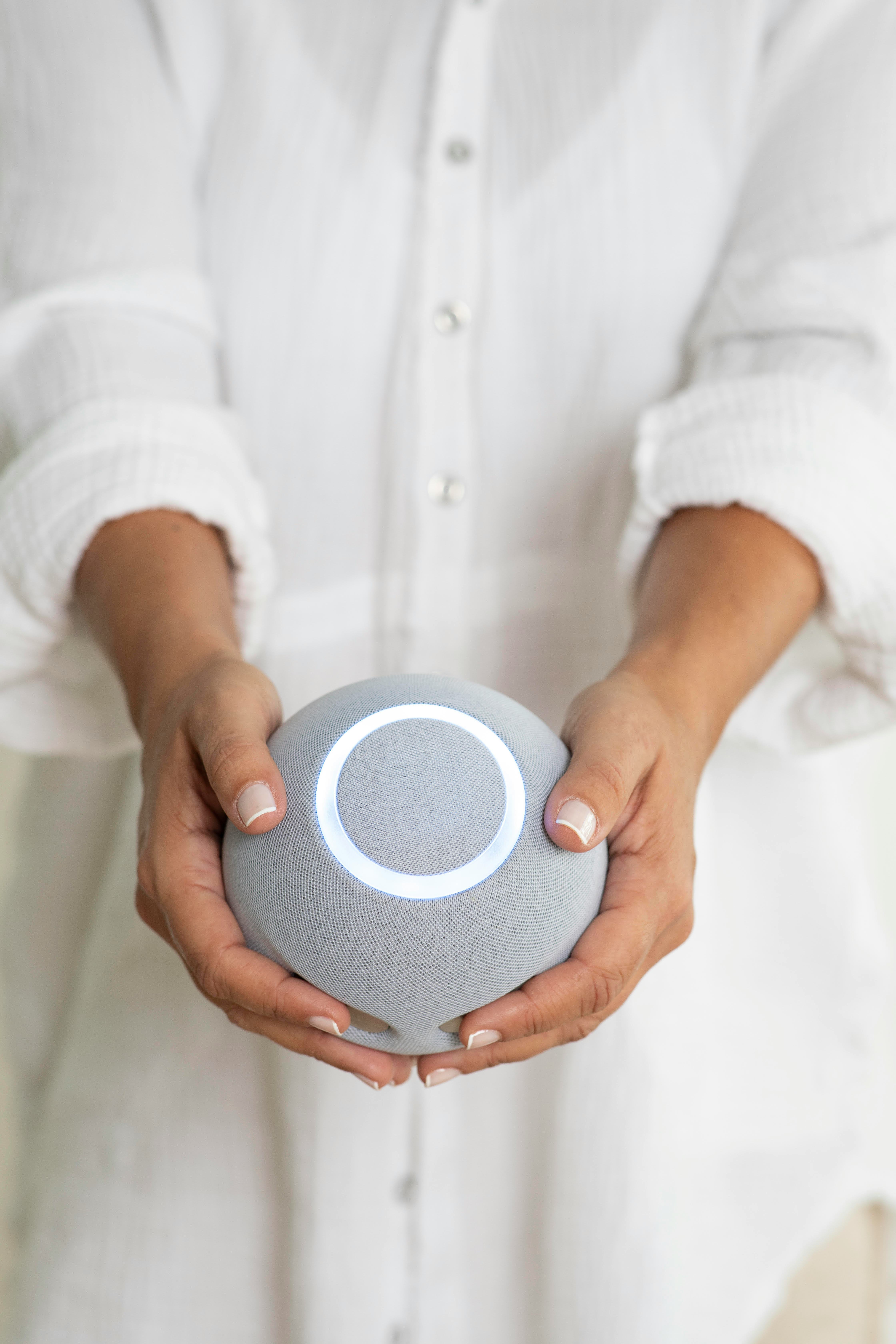 Woman in white holding The Reflect Orb in front of her.