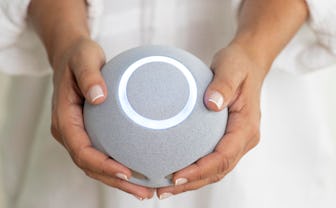 Woman in white holding The Reflect Orb in front of her.