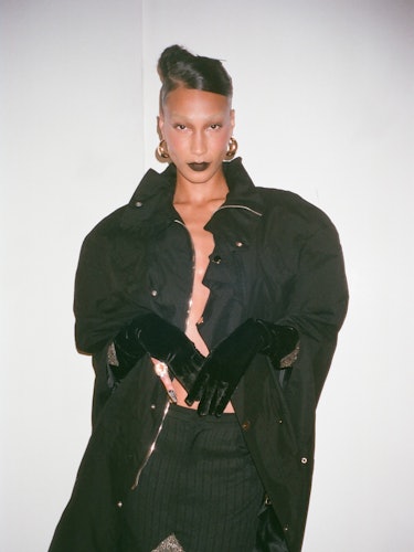 A model posing in a black coat of Luar’s designer Raul Lopez