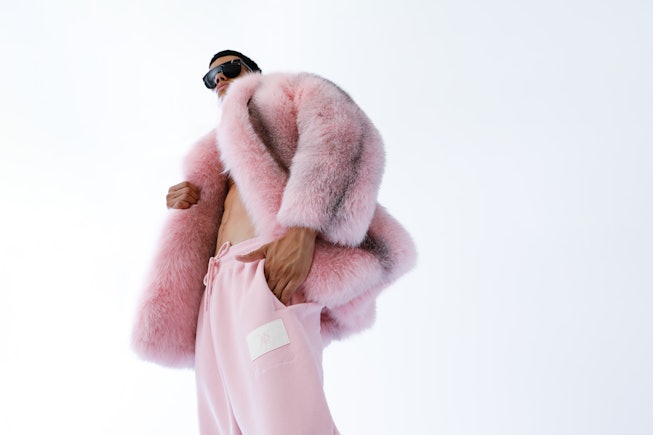 Model in a pink fur coat and pink trainers
