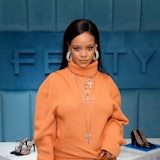 Rihanna wearing an orange turtleneck dress at a Fenty event