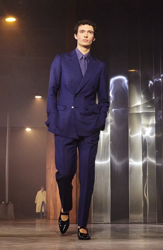 A model wearing a navy suit and black Mary Janes