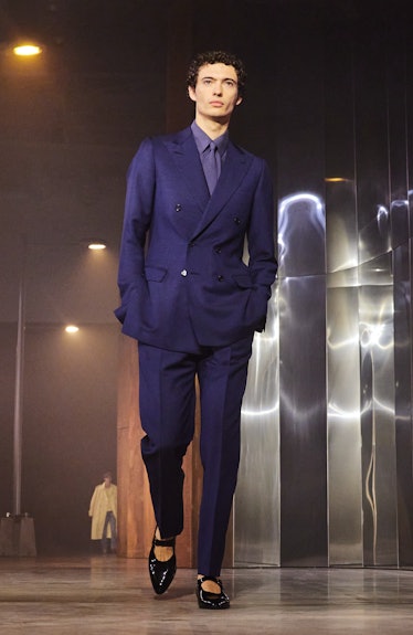 A model wearing a navy suit and black Mary Janes
