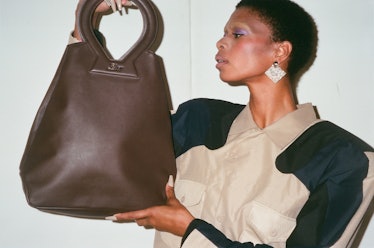 A model posing with Raul Lopez’s bag and dress