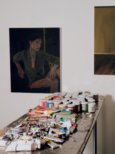 Artist Danielle Mckinney on 'Golden Hour' at Marianne Boesky Gallery 3 Danielle paints on a work table and some of her works on the wall above the table.