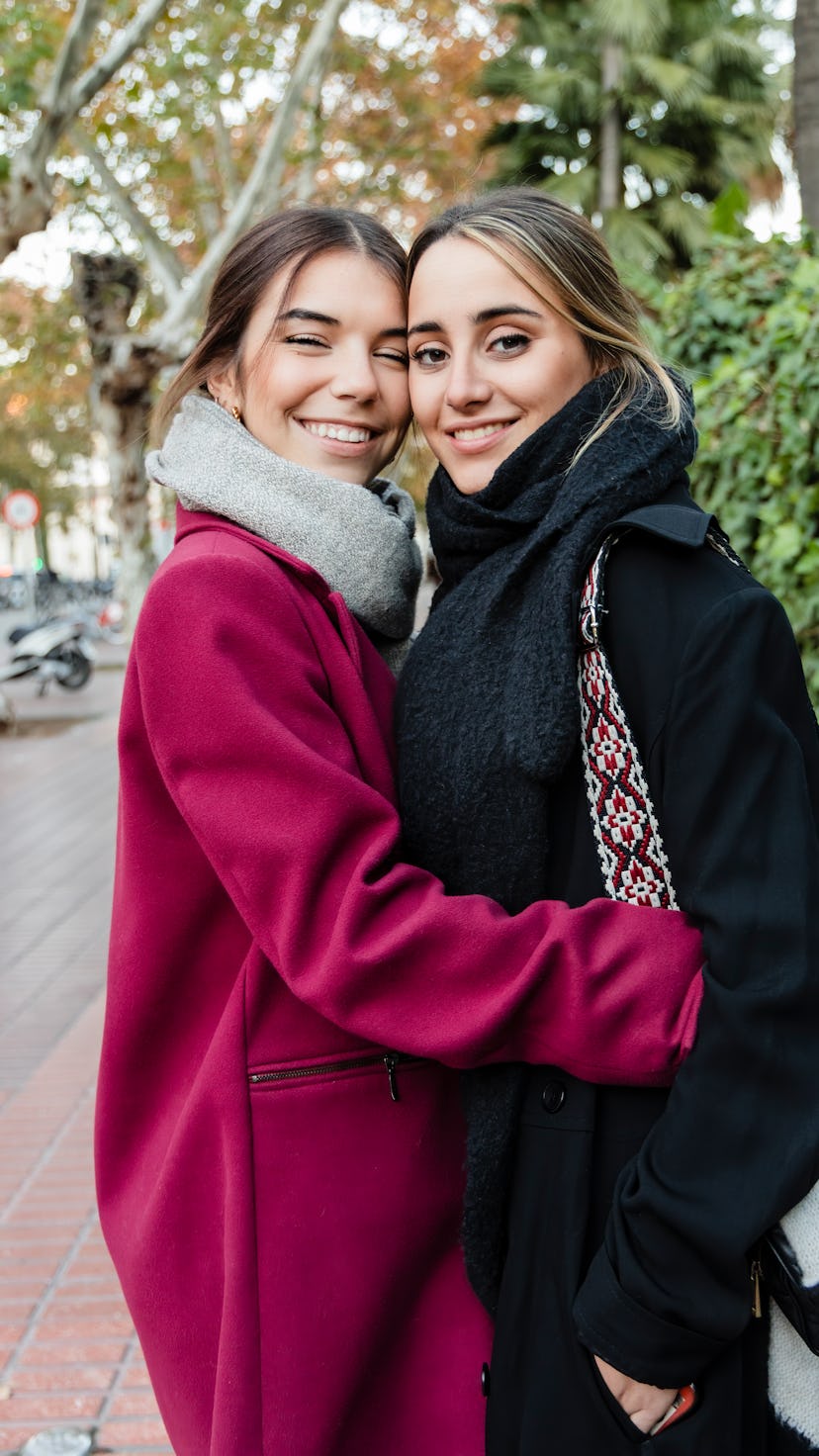 A young couple hugging in their coats on the most romantic day in October 2022.