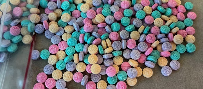 An assortment of colorful pills spilling out of a plastic bag. The DEA is warning parents about so-c...