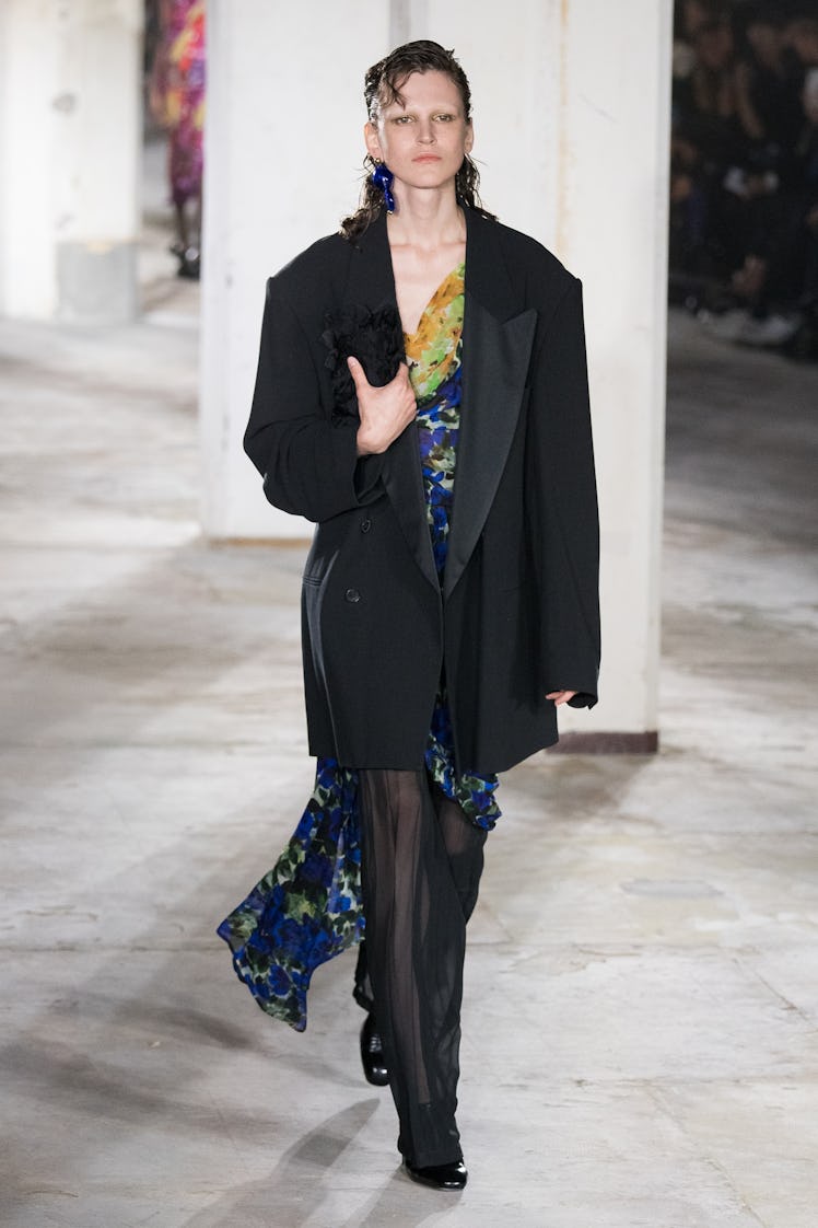 A model wearing Dries Van Noten yellow & blue cocktail dress and oversized black blazer at Paris Fas...