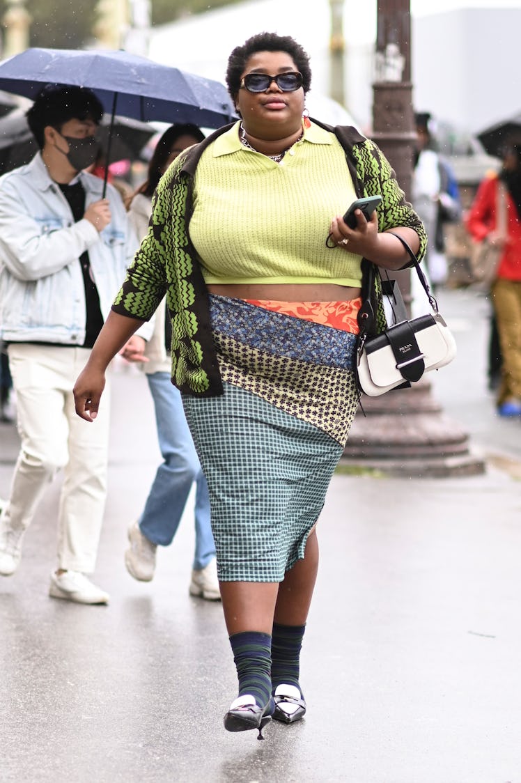 Gabriella Karefa-Johnson is seen wearing a bright green top, black and green cardigan, printed skirt...