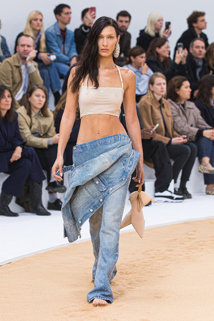 Bella Hadid in Courrèges transparent glitter crop top, glitter jeans, and glitter jacket at the Pari...