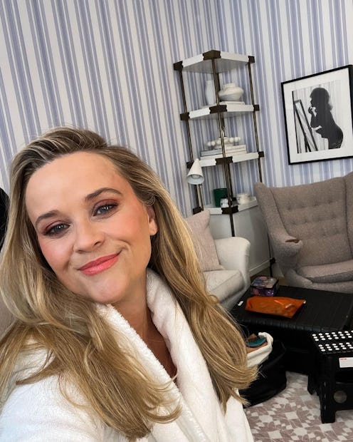 Reese Witherspoon in a white robe posing in her new powder room