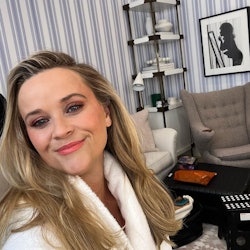 Reese Witherspoon in a white robe posing in her new powder room