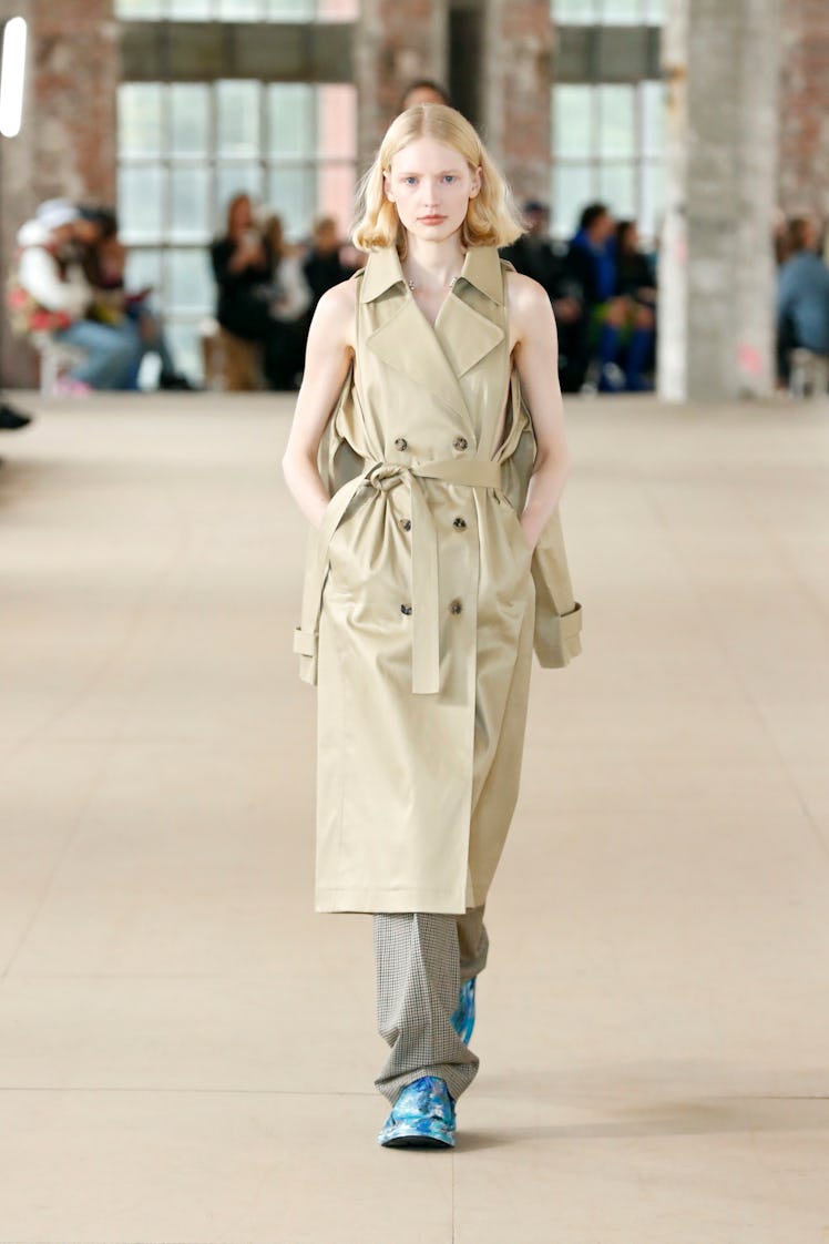 A model wearing Botter beige leather coat and checkered pants at the Paris Fashion Week Spring 2023