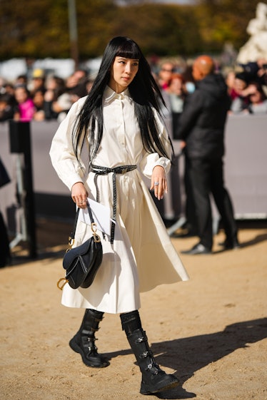 Irene Kim wears a white shirt / long sleeves / midi dress from Dior, a black shiny leather nailed / ...