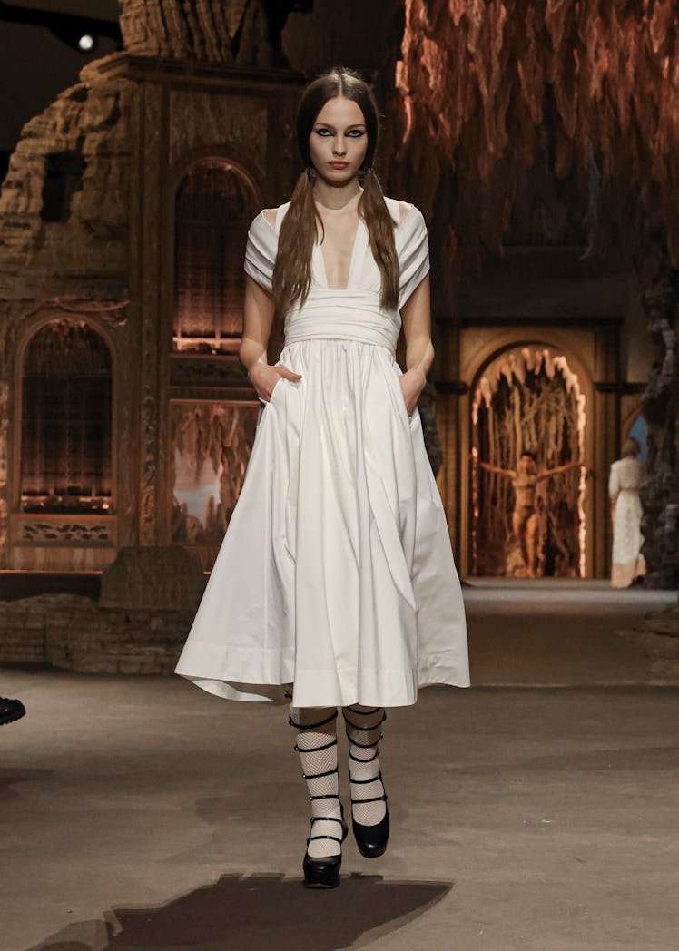 A model in Dior’s white dress and black boots at the Paris Fashion Week Spring 2023