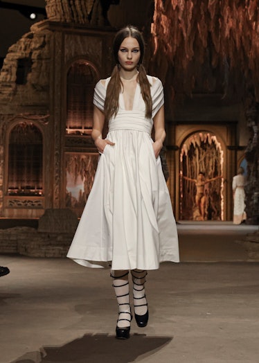 A model in Dior’s white dress and black boots at the Paris Fashion Week Spring 2023