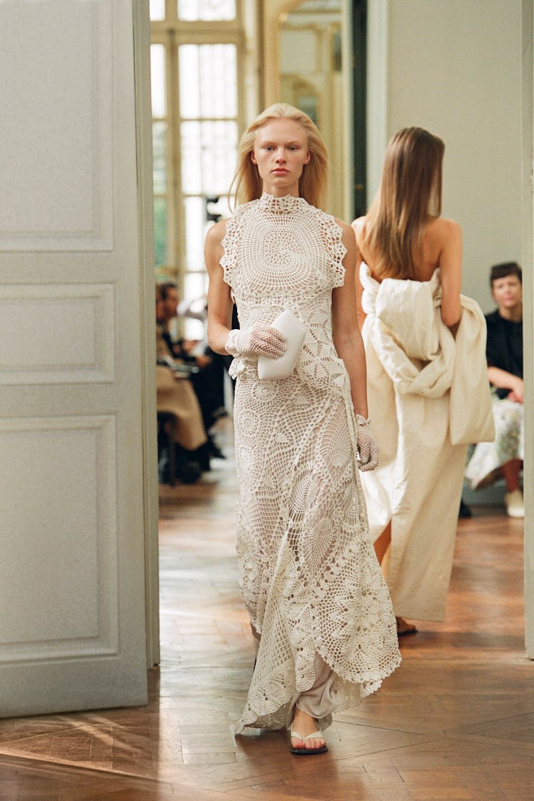 A model in The Row knitted maxi white dress and knitted gloves at the Paris Fashion Week Spring 2023