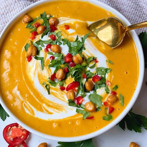 Bowl of butternut squash soup and the coconut curry garnished with greens and cream, perfect for fal...