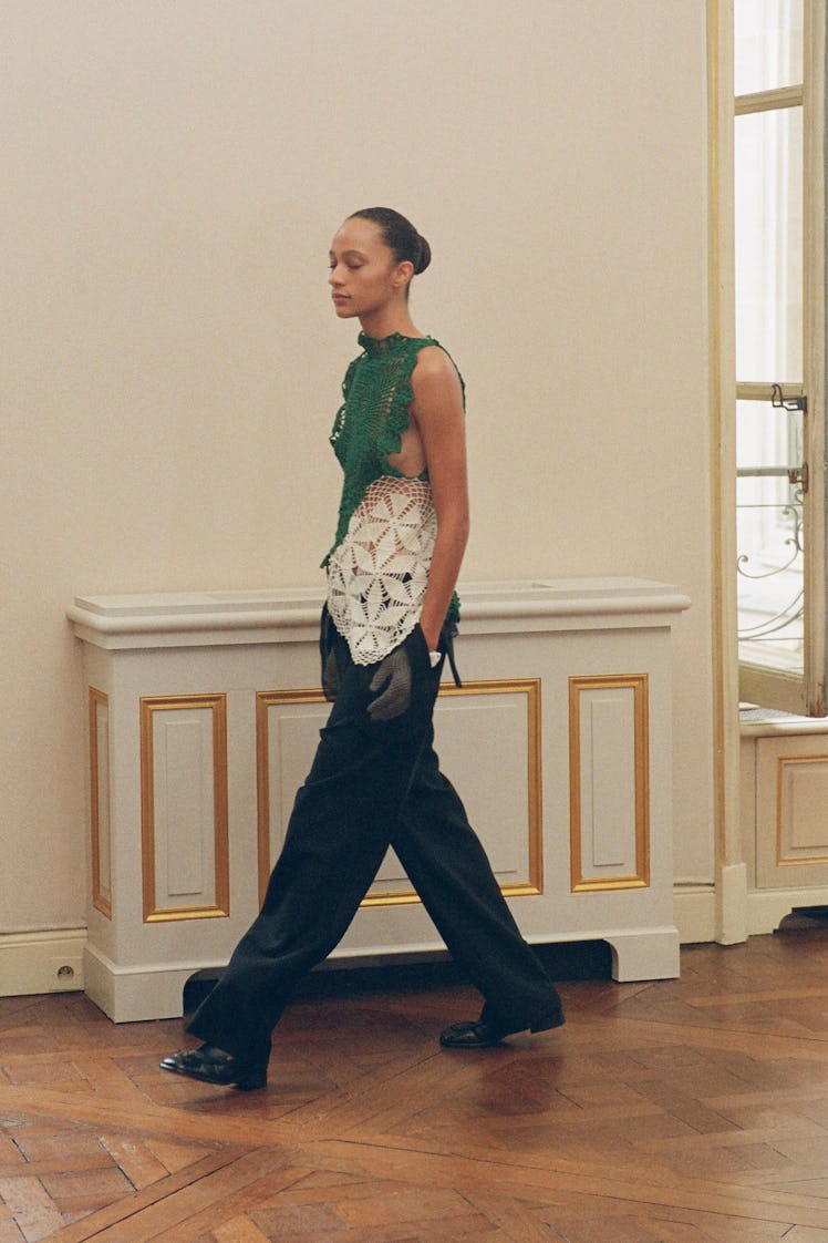 A model walking in The Row’s knitted green and white knitted top and black pants at the Paris Fashio...