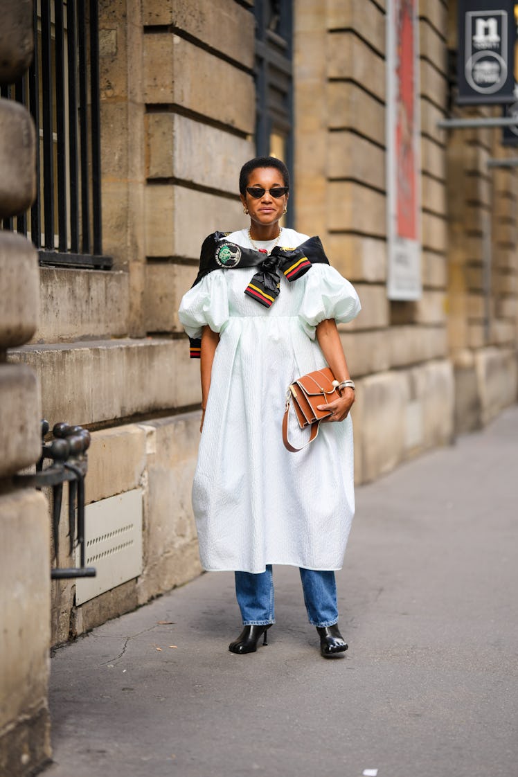 Tamu McPherson wears black cat eyes sunglasses, gold earrings, a white pearls with red strawberry pe...