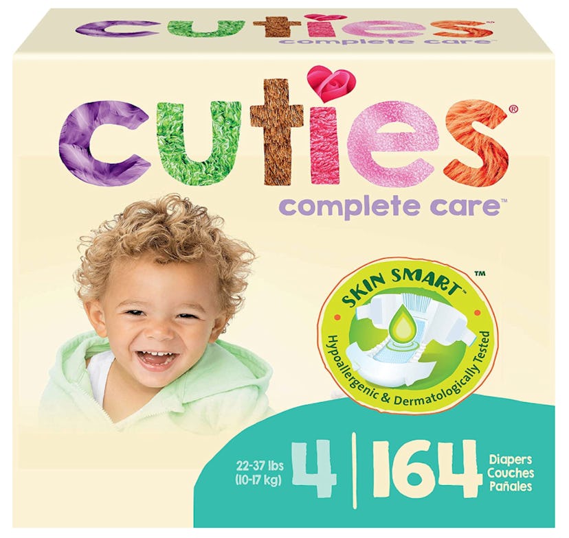 Laughing baby boy on Cuties diaper packaging with multicolor font