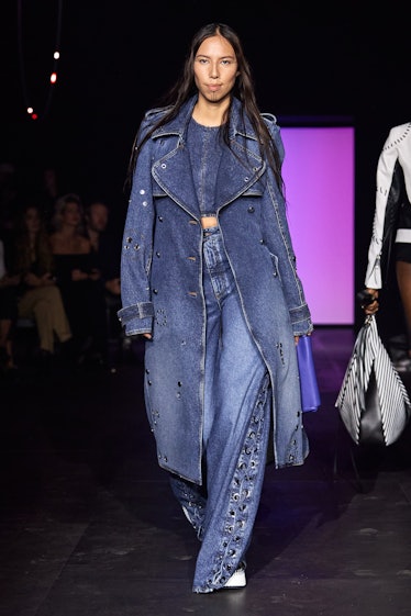 A model in Chloé all-denim crop top, jeans, and coat at Paris Fashion Week Spring 2023.