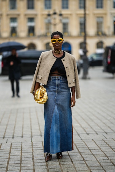A guest wears yellow sunglasses from Loewe, a gold large necklace with Love large details, a black l...