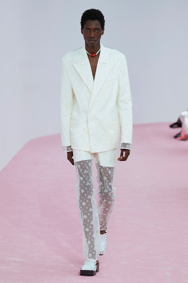 Male model in Acne Studios white blazer and lace pants at Paris Fashion Week 2023