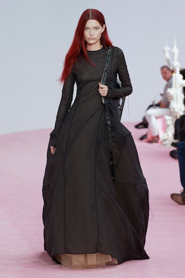 A model wearing a black maxi dress by Acne Studios at Paris Fashion Week 2023