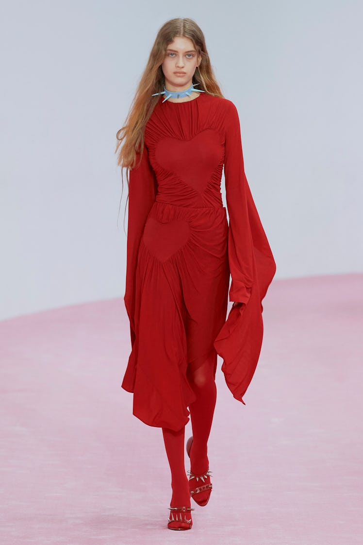 A model in Acne Studios’ red dress, leggings, and sandals styled with a sky-blue choker at Paris Fas...