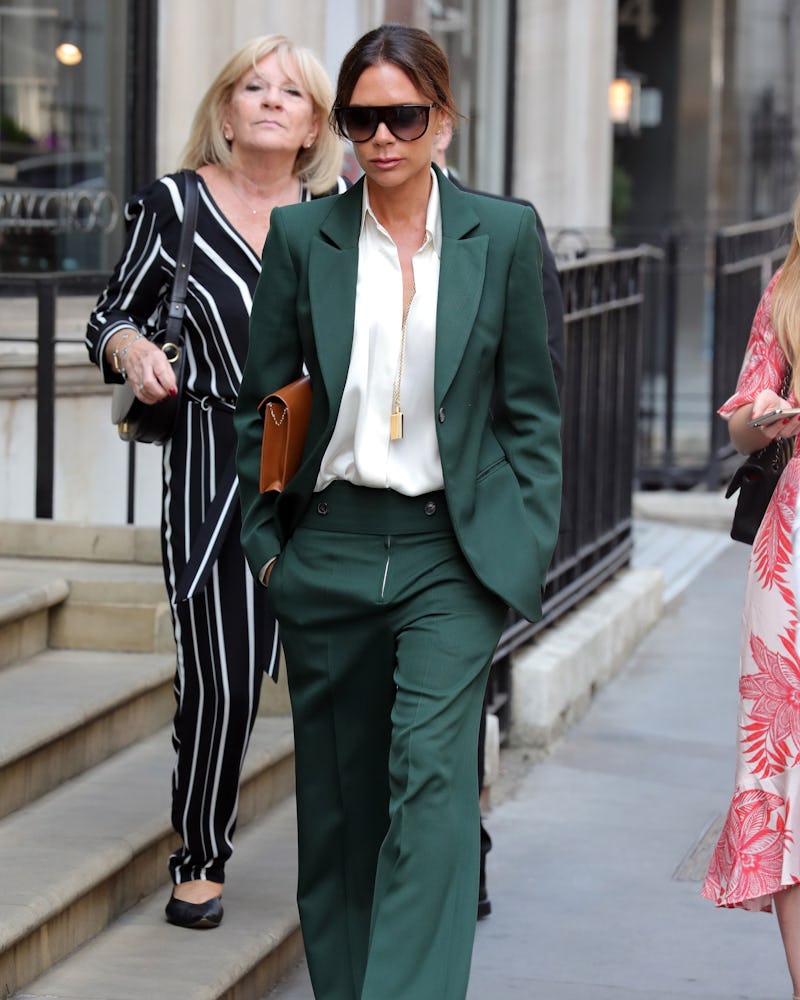 Victoria Beckham wearing a green tailored suit.