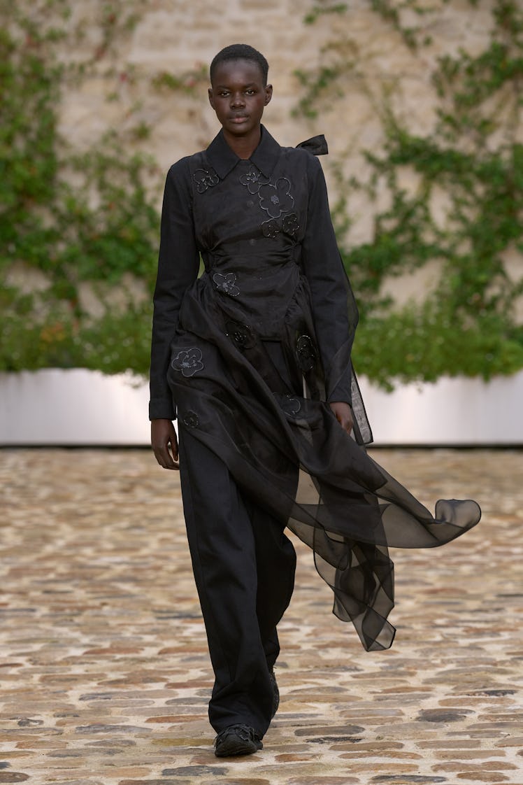 A model in Cecilie Bahnsen’s black jumpsuit dress with silver flower details at Paris Fashion Week S...
