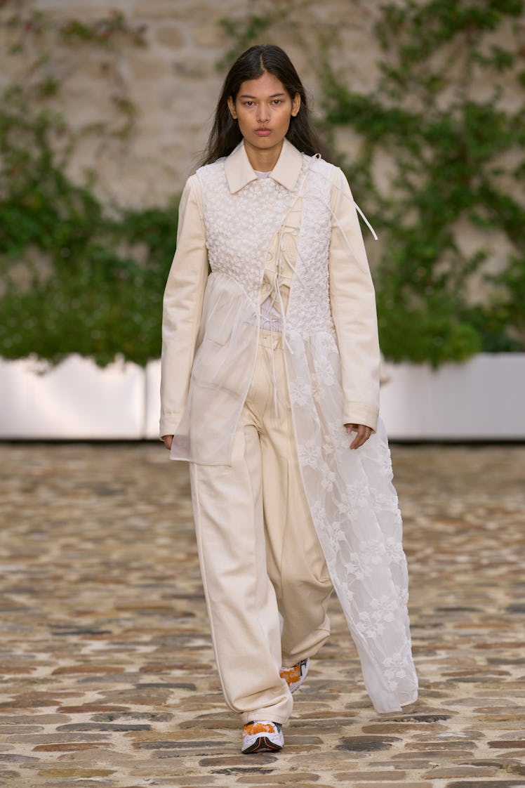 A model in Cecilie Bahnsen’s nude pants, top, and lace cover dress at Paris Fashion Week Spring 2023