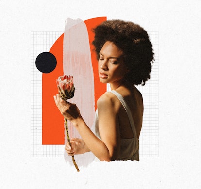 A curly woman in perimenopause holding a flower