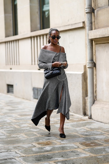 A guest wears black sunglasses, gold earrings, a gray print pattern shoulder-off / long sleeves / as...