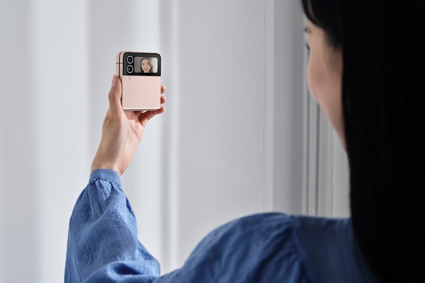 Woman using the Samsung Galaxy Z Flip 4 in selfie mode.