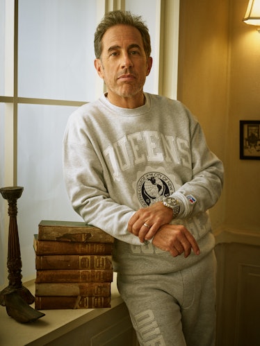 Jerry Seinfeld leaning on a stack of books in his Kith campaign