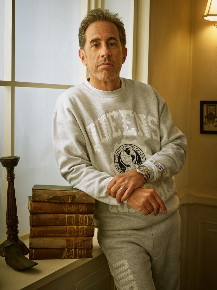 Jerry Seinfeld leaning on a stack of books in his Kith campaign