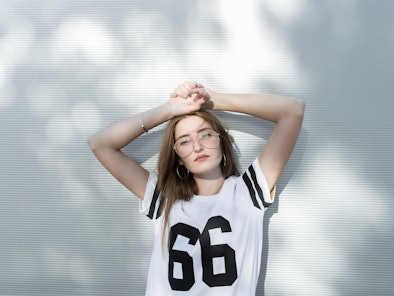 Young woman wearing T-shirt with number 66 on it during Mercury retrograde fall 2022, which will aff...