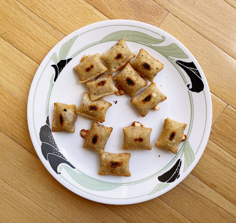 Slightly burnt pizza rolls on a plate.