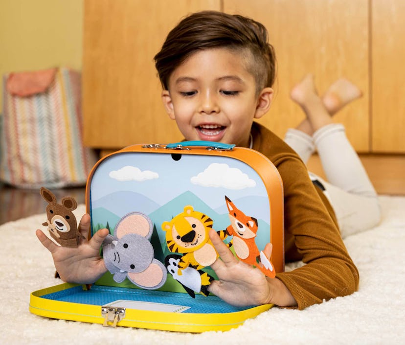 child on floor playing with little passports box and puppets