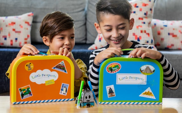 two kids playing with suitcases