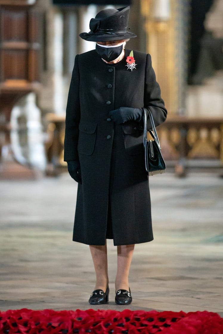 Queen Elizabeth wearing a black face mask and coat