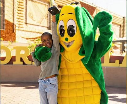 Tariq and posing with an ear of corn mascot.