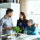 Man in kitchen talking to older woman and younger woman