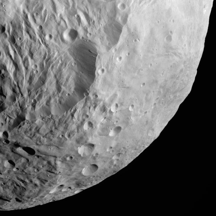 image of a solar system body — vesta — with craters strewn across it