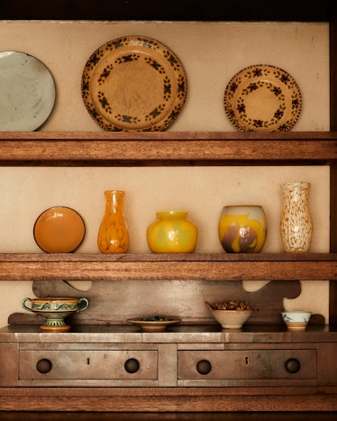 Shelves filled with orange dishes and drawers inside the Rose House